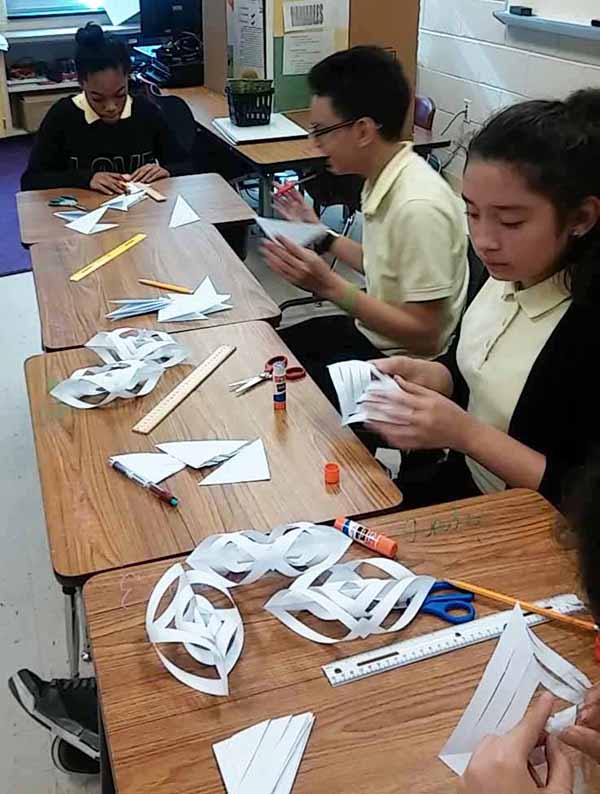 math-students-creating-three-dimensional-shapes-with-paper.jpg