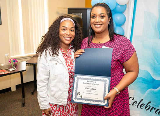 teacher holding award certificate