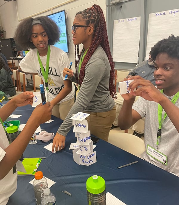 students building card tower with sports terminology notecards