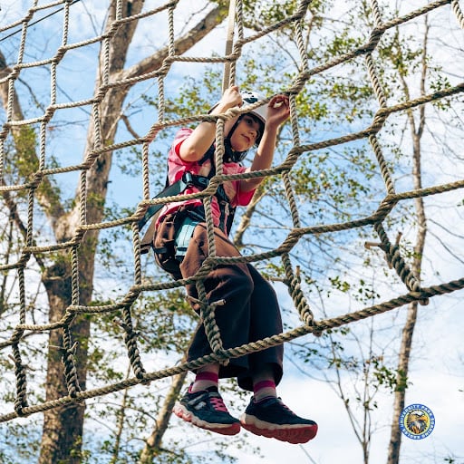 student climbing on rope course