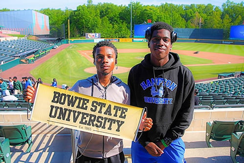 graduates-holding-Bowie-State-University-banner