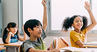 LC-elementary-students-in-class-raising-hands.jpg