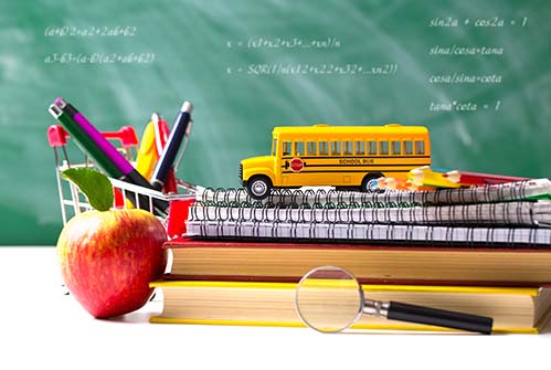 M-back-to-school-apple-bus-sitting-on-stack-of-books-on-desk-blackboard-background.jpg