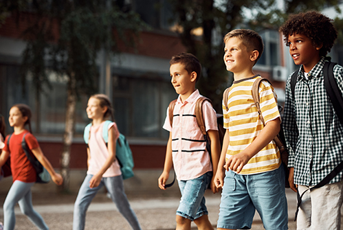 M-elementary-students-walking-outside-backpacks.jpg